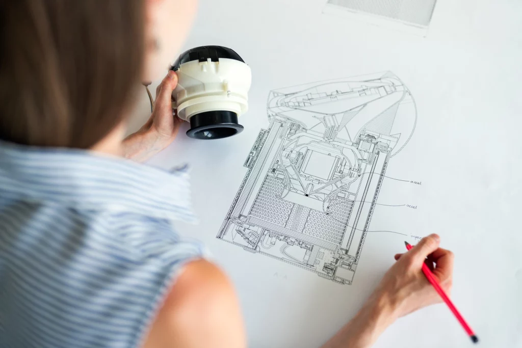 person draws house plans with pencil