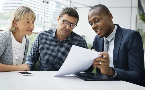 People sitting at table looking over papers